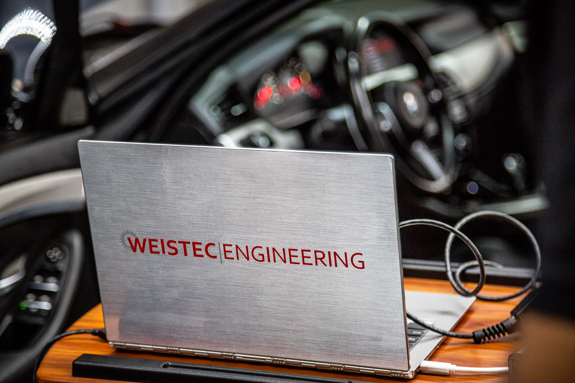 Laptop on bench with Mercedes in background during tuning process