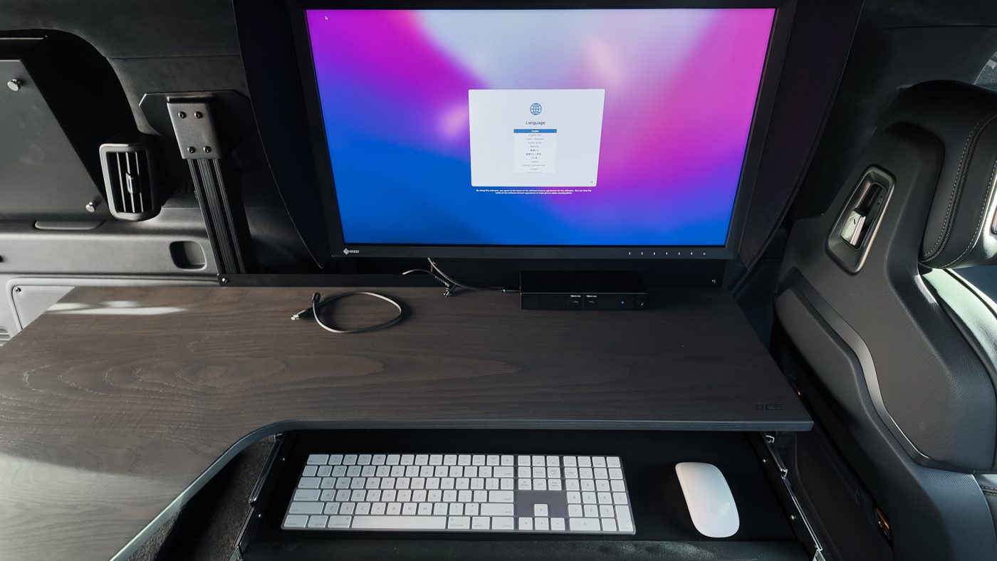 DIT workstation built into the rear of the Rivian R1S with a large monitor and keyboard