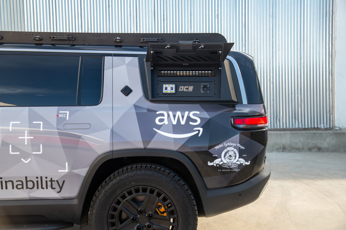 Side view of the wrapped Rivian R1S with AWS sustainability branding