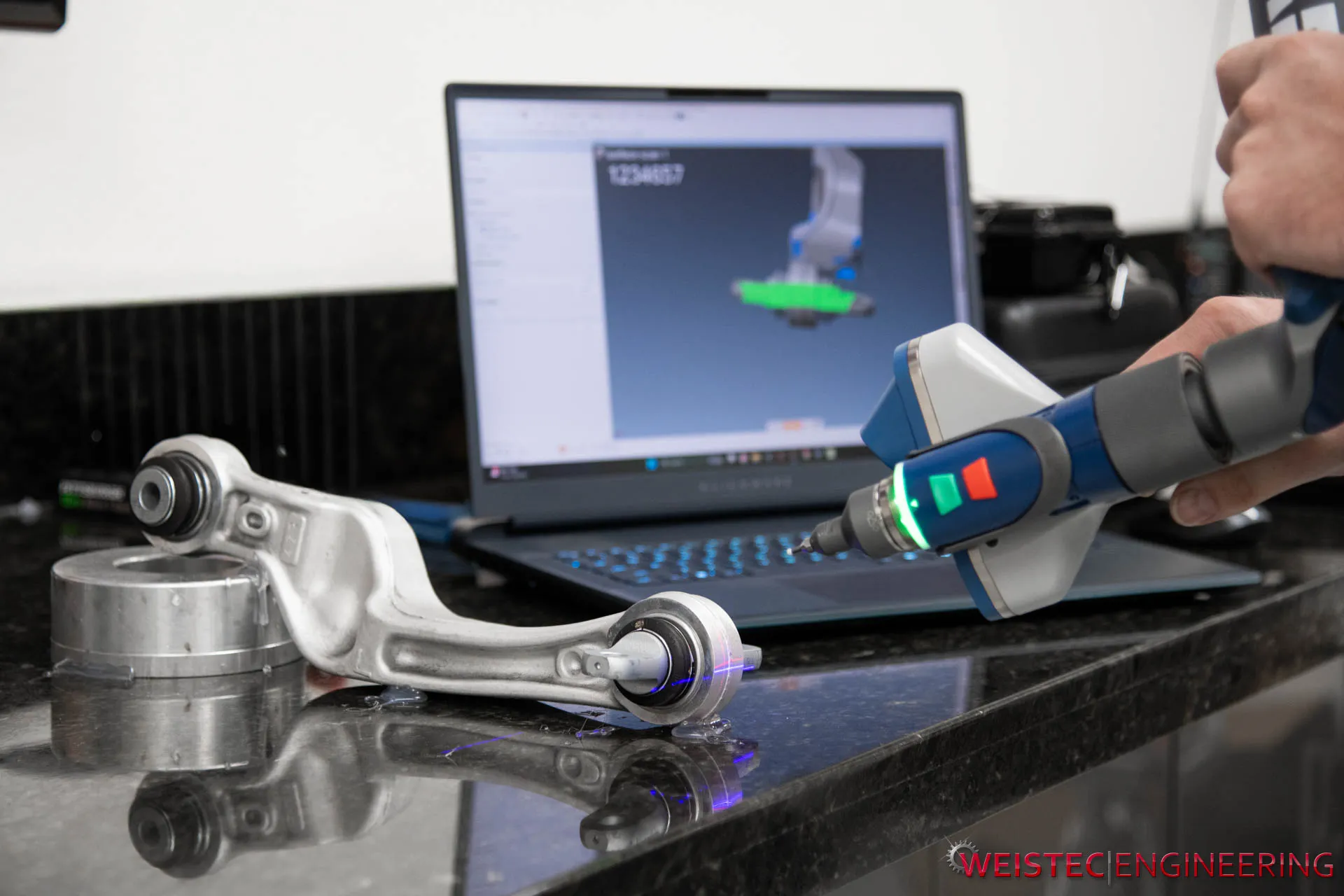 Tesla model s control arm being 3d scanned and model displayed in background