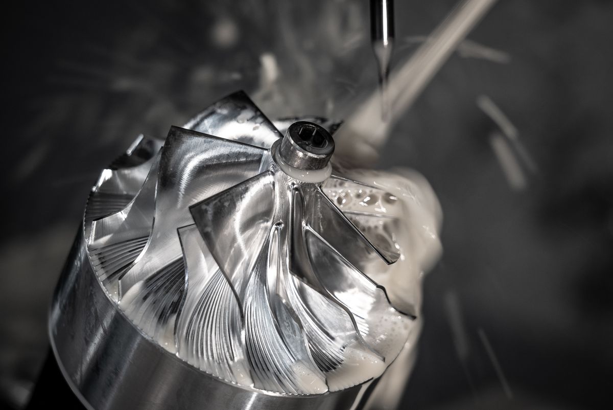 Billet compressor wheel being 5-axis machined with coolant spray